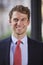 Young white businessman smiling, vertical portrait