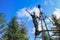 Young white Caucasian male tourist in sportswear climbed onto an iron tower in the mountains