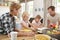 Young white family busy together in their kitchen, close up