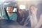 Young white family of four setting off on a journey in their car, seen through front windscreen