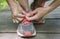 A young white woman ties laces on her running shoes