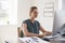 Young white woman working in office using computer, close up