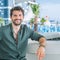 Young wide smiling happy man model portrait in outdoor cafe