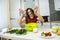 Young wife preparing salad with vegetables add salt and pepper for better taste