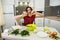 Young wife preparing salad with vegetables add salt and pepper for better taste