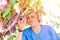 Young winemaker in straw hat examining grapes