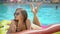 Young woman 20s laying and relaxed near pool at summer holiday. Bikini girl sunbathing lying on inflatable