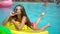 Young woman 20s laying and relaxed near pool at summer holiday. Bikini girl sunbathing lying on inflatable