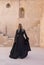 Young woman in an abaya traditional emirati dress in an old castle