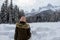 A young woman admiring the snowy views of Island Lake in Fernie, British Columbia, Canada.The majestic winter background is pretty
