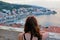 A young woman admiring the view from a top the bell tower in the town of Korcula during sundown of the beautiful ancient town