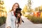 Young woman with adorable Brussels Griffon dog in park