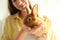 Young woman with adorable rabbit, closeup. Lovely pet