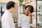 Young woman african american choosing spectacles glasses with man professional optician ophthalmologist keep introducing at store