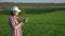 Young woman agronomist in the field with a digital tablet