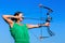 Young woman aiming arrow of compound bow