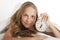 Young woman with alarmclock on the bed at morning