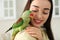 Young woman with Alexandrine parakeet, closeup. Cute pet