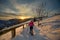 Young woman alone on snowshoe hike on beautiful sunset day