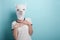 Young woman in alpaca mask hold her hands on chest in surprised, pleasantly unexpected expression