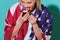 young woman with american flag eating cupcake on blue backdrop, celebrating 4th