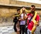 Young woman ande man making photo with a huge yellow boa snake constrictor on the neck, Old Town, Prague, Czech Republic