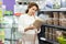 Young woman in animal goods store examines packaging of dry food for turtles