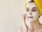 Young woman applying facial clay green mask. Beauty treatments concept with copy space. Close Up portrait