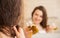 Young woman applying oil mask to hair tips