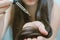 Young woman applying oil onto her hair, indoors