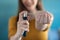 Young woman applying perfume on her wrist while standing at home