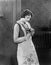 Young woman in an apron holding herbs