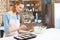 Young woman in apron preparing form for baking cookies