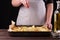 Young woman in apron seasoning salt potatoes