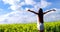 Young woman with arms outstretched standing in field