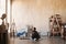 Young woman artist sitting on a floor of an art studio