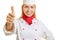 Young woman as chef cook holding thumb up
