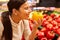 Young woman as a customer smells fresh yellow peppers