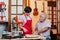 Young woman as trainee learns with luthier