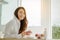 Young woman asia wake up refreshed in the morning and relaxing eat coffee, cornflakes, bread and apple for breakfast at house on h