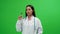 Young woman asian doctor shows a syringe at the vaccine atmosphere behind Green Screen.