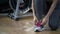 Young woman asian knelt down to do up his shoelaces at fitness g