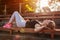 Young woman athlete having rest after running on sportsground in summer