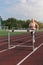 Young woman athlete runnner running hurdles