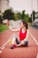 Young woman athlete at the stadium sporting lifestyle, sitting on the track, taking selfie photo on a smartphone