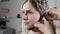 Young woman attending clinic for neurological evaluation using EEG machine. Female doctor operating