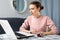 Young woman attentively working on laptop at home