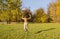 A young woman in an autumn park enjoys freedom. She jumps and gesticulates widely