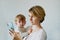 Young woman with a baby in her arms calls on the phone