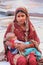 Young woman with a baby sitting in Jama Masjid, Delhi, India